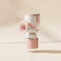 Compact white and pink breast pump in a warm studio setting