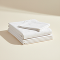 Soft white baby bed sheets in a warm studio setting
